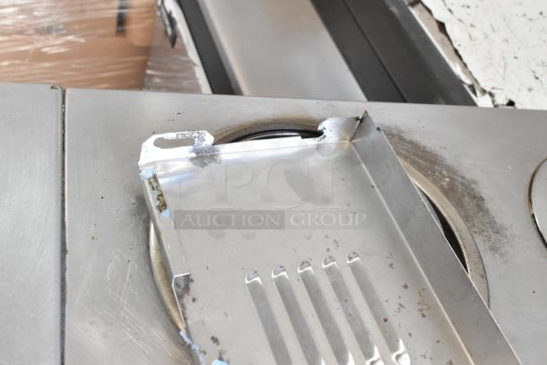 Garland stainless steel commercial electric range with 6 burners, oven, and commercial casters. 120/250V, 3 phase. Some surface wear visible.