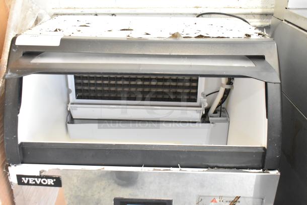 Vevor SKF-E150F metal undercounter ice machine, 110V, 1 phase. Shows signs of wear, front logo and caution label visible.