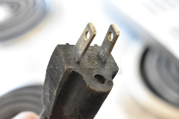 Close-up view of a 110-volt power plug, showing prongs and markings, likely from a Vevor SKF-E150F ice machine.