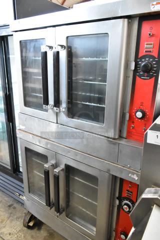 Two stainless steel commercial electric convection ovens with view-through doors, metal racks, thermostatic controls, on casters.