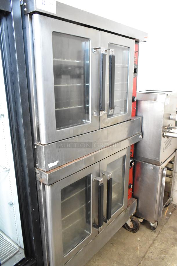 Stainless steel commercial electric convection ovens, dual units with view-through doors, metal racks, thermostatic controls, on casters.