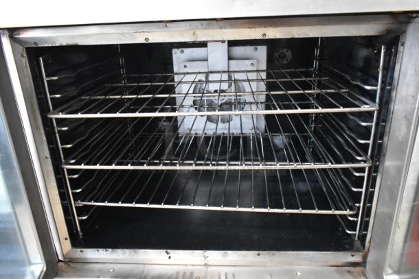 Stainless steel commercial electric convection oven with view-through door, metal racks, and thermostatic controls.