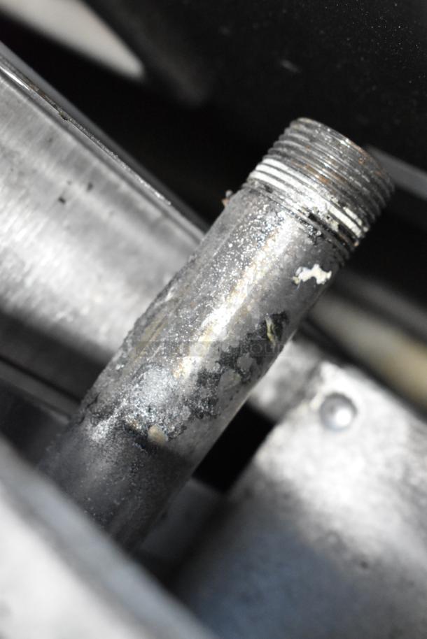 Close-up of a metal pipe component, possibly part of the 2018 Therma-Tek TMD48-8-2N range. Visible wear and grime on surface.