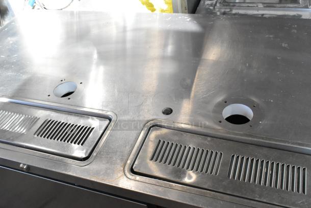 Beverage Air DD58HC-1-S stainless steel kegerator top view, showing tap holes and vents. Commercial casters visible.
