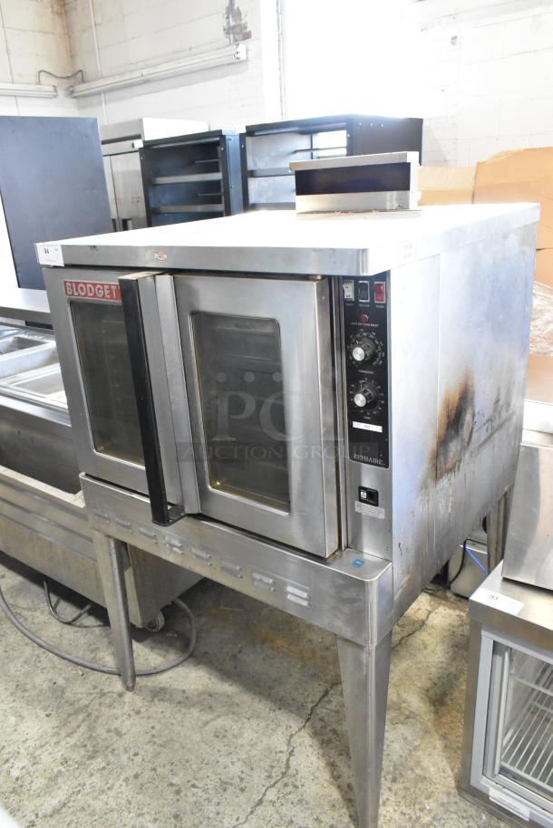 Blodgett stainless steel convection oven, gas-powered, view-through doors, metal racks, thermostatic controls, on metal legs.
