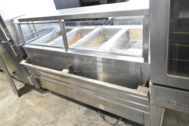APW Wyott TM-90D stainless steel 4-bay steam table; includes tray slide, sneeze guard, under shelf; on commercial casters.
