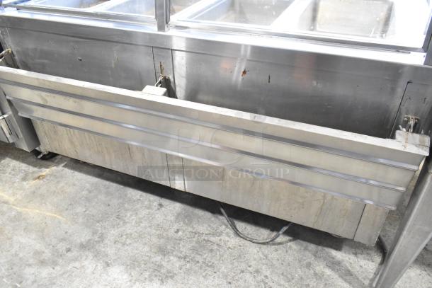 APW Wyott TM-90D stainless steel 4 bay steam table with tray slide, sneeze guard, and under shelf on casters.
