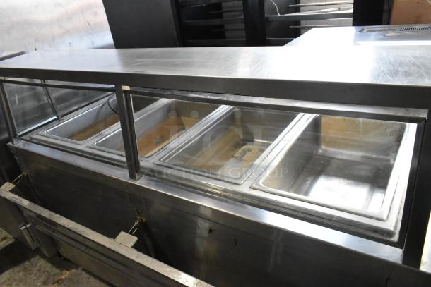 APW Wyott TM-90D stainless steel 4-bay steam table with tray slide, sneeze guard, under shelf, and commercial casters.