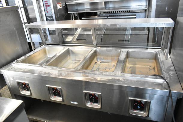 APW Wyott TM-90D stainless steel 4-bay steam table with tray slide, sneeze guard, undershelf, and casters. 208-240V.