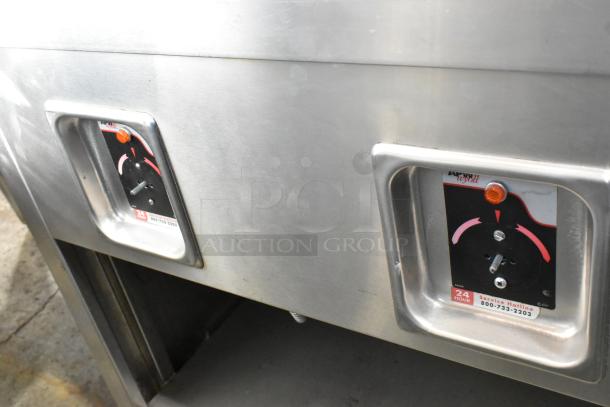 APW Wyott TM-90D stainless steel steam table controls, features tray slide, sneeze guard, under shelf, on casters.