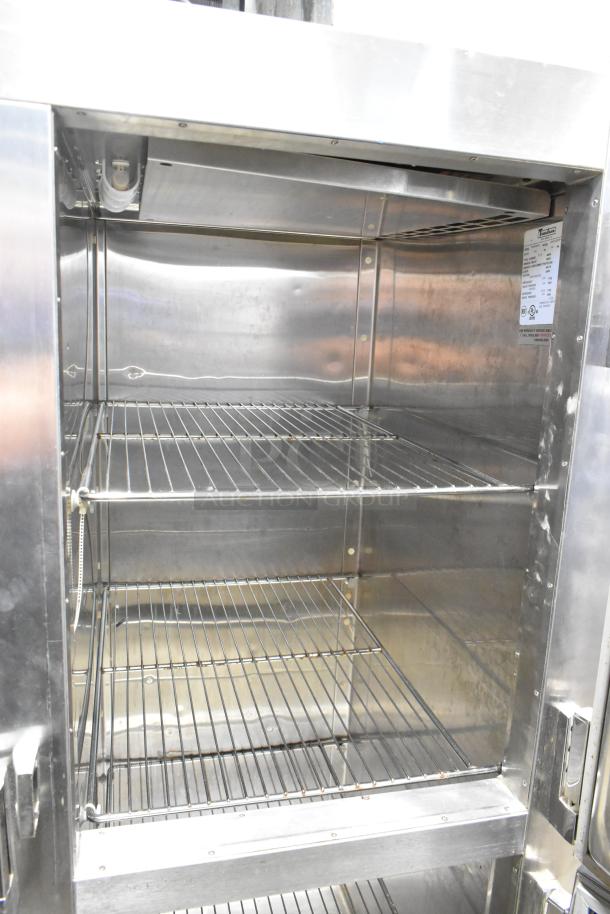 Traulsen RDT332NUT-HHS commercial stainless steel refrigerator/freezer interior with metal racks, model label visible.