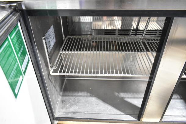 Turbo Air MUF-48 stainless steel 2-door undercounter freezer, commercial casters, interior shelves, side label visible.