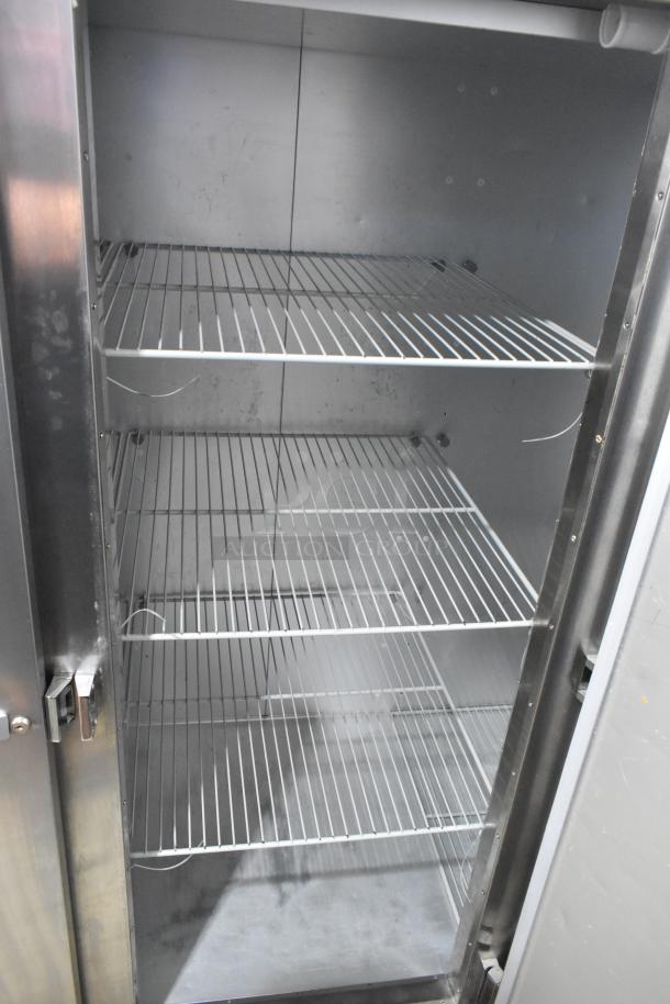 2018 Traulsen G30010 stainless steel 3-door commercial cooler with poly coated racks, open door view, on casters.