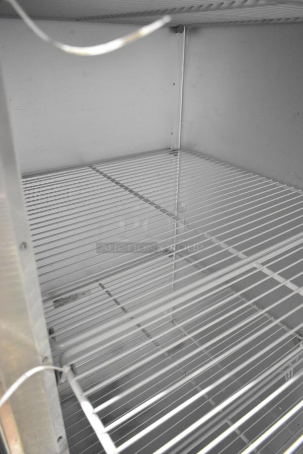 2018 Traulsen G30010 stainless steel 3-door reach-in cooler, features poly-coated racks, on commercial casters. Doors locked.