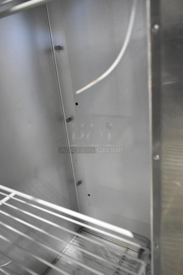 2018 Traulsen G30010 stainless steel 3-door reach-in cooler interior view with poly-coated racks and commercial casters.