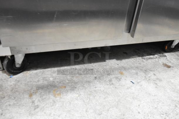 2016 Traulsen G20010 stainless steel 2-door reach-in cooler with poly-coated racks and commercial casters. Left door locked.