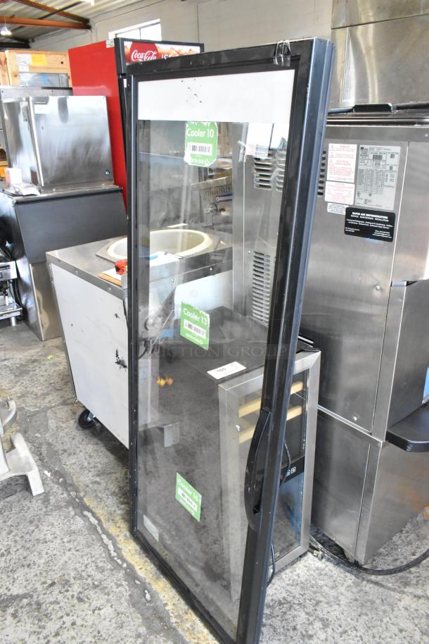 Glass door for merchandiser with black frame, transparent surface, and visible labels. Good condition.