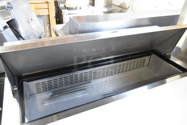 Dukers DSP48 stainless steel sandwich salad prep table, mega top, 115V, 1 phase, on commercial casters, excellent condition.