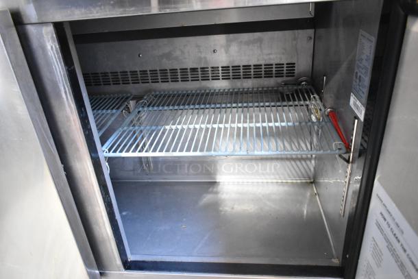 Dukers DSP48 stainless steel interior of commercial sandwich salad prep table. Features adjustable shelf, clean surface, Bain Marie top.