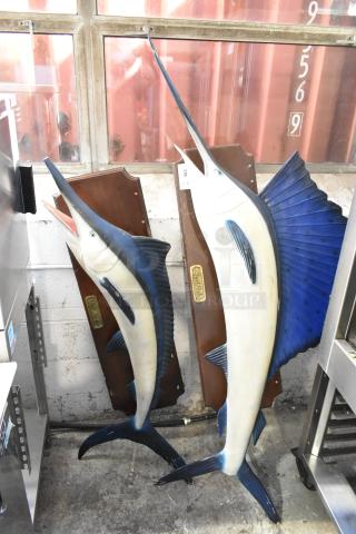 Two decorative fish plaques featuring a Blue Marlin and Sailfish, mounted on wood, vibrant colors, used condition.