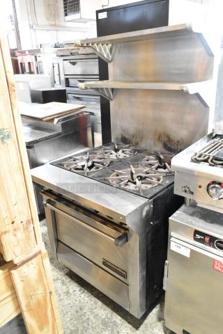 Garland M44R stainless steel 4 burner range with oven, backsplash, and 2-tier over-shelf. Natural gas powered, commercial use.