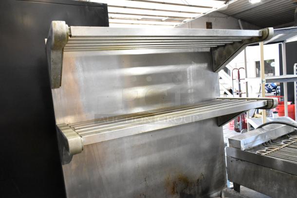 Garland M44R stainless steel 4 burner range with oven, back splash, and 2-tier over shelf. Minor wear visible.