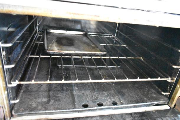 Garland M44R stainless steel oven interior with racks and a baking tray, showing used condition.