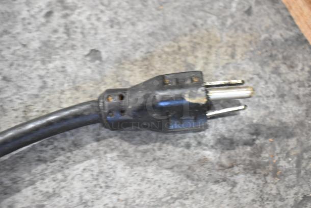 Black power plug for Hobart 84186 Buffalo Chopper, showing three prongs, used condition on gray countertop surface.