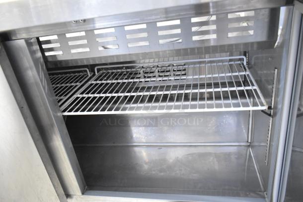 Avantco 178SSPT60MHC stainless steel prep table interior, showcasing wire shelving. Commercial casters not visible.