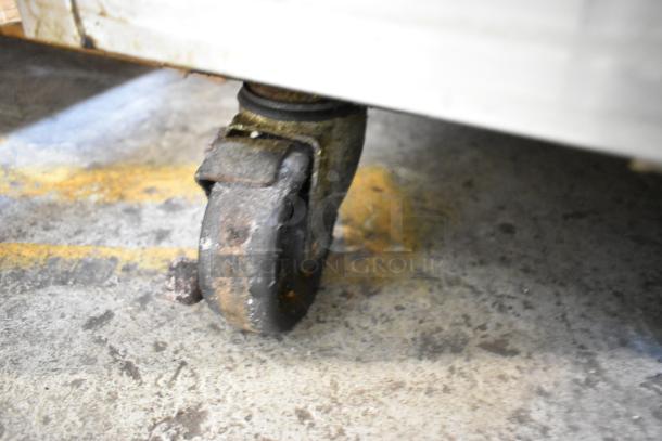 Turbo Air TPR-44SD-D2 pizza prep table caster, showing moderate wear on concrete floor.