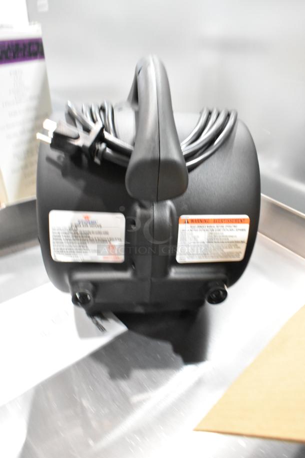 Brand new Xpower P-80A Air Mover in box, black with attached cord and handle, product label visible.