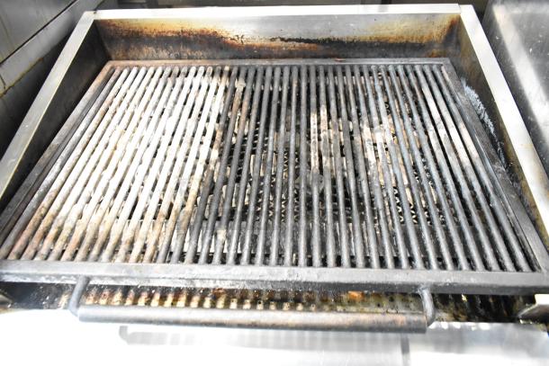 MagiKitch'n 636 stainless steel commercial natural gas charbroiler grill, visible wear, with under shelf on commercial casters.