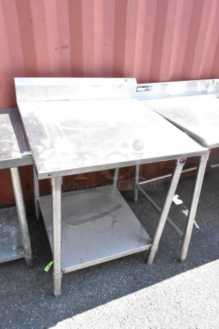 John Boos stainless steel table with metal under shelf, industrial style, signs of wear visible, ideal for kitchen use.