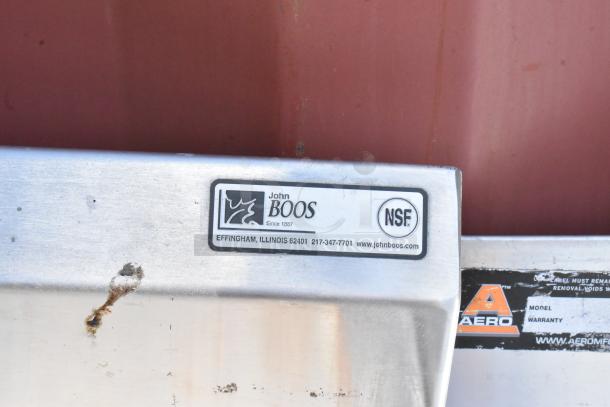 John Boos stainless steel table with metal under shelf, visible label shows NSF certification, minor surface rust present.