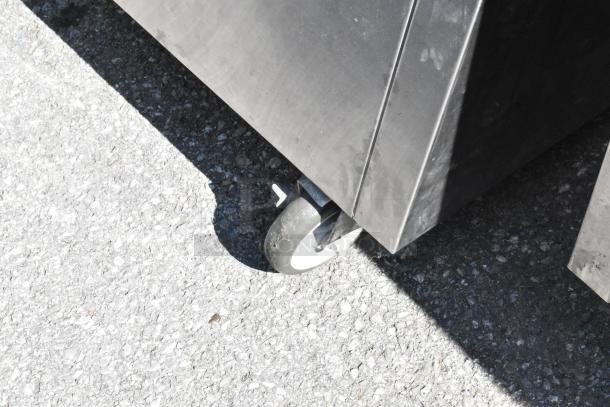 Delfield stainless steel steam table wheel, showcasing mobility feature. Condition appears used with visible surface marks.