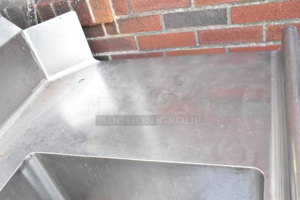 Stainless steel 3 bay sink with left side drain board, shows minor wear, ideal for commercial kitchens.