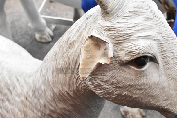 Close-up of a goat statue's face, showing detailed texture and realistic features, in good condition.