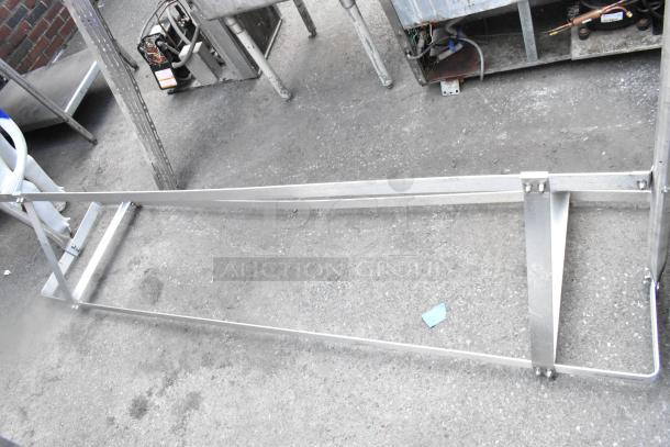 Metal pot rack with a rectangular frame and supportive brackets. In good condition, suitable for kitchen use.