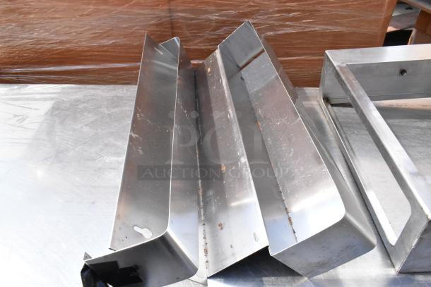 Stainless steel table with under shelf and contents, showing a smooth surface and attached metallic items. Ideal for industrial use.