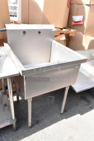Stainless Steel Single Bay Sink, durable, with backsplash and four sturdy legs. Good condition, ideal for commercial use.