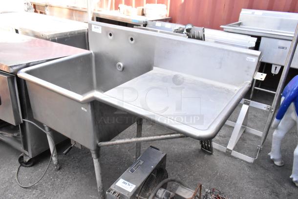 Stainless steel single bay sink with right side drain board. Shows signs of wear. Ideal for commercial kitchens.