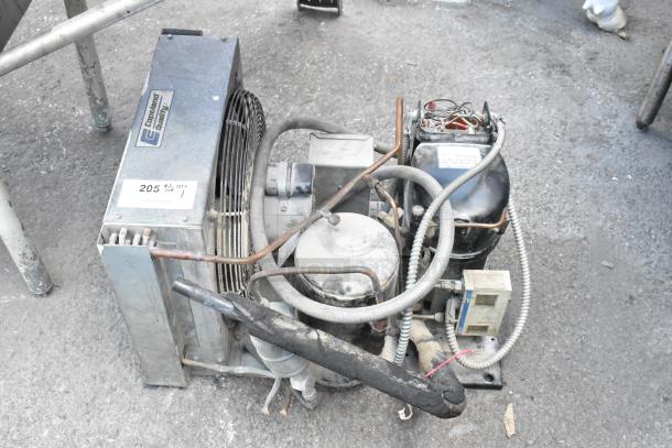 Copeland REK3-0125-PFV-959 compressor, 208/230V, 1 phase, with visible labeling. Used condition on outdoor surface.