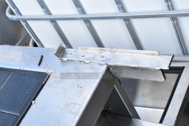 Stainless steel commercial warming table with visible wear and screws. Ideal for food service, durable construction.