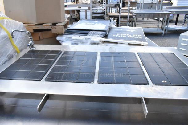 Stainless steel commercial warming table with black tiled surface, faucet, and multiple heating zones. Good condition.