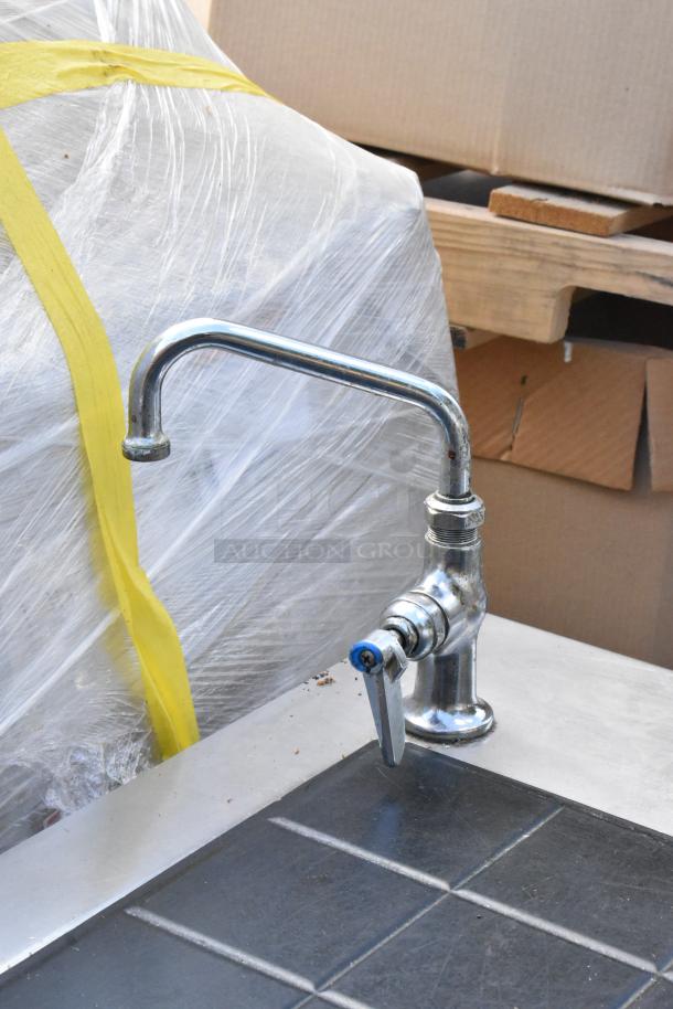 Stainless steel commercial warming table with integrated faucet, shown in good condition. Rust and wear are minimal.