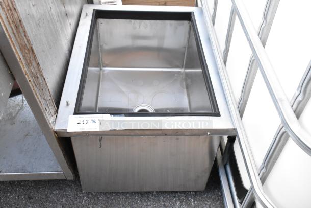 Stainless steel drop-in ice bin with drain, lightly used, rectangular shape, visible label with auction site details.