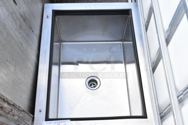Stainless steel drop-in ice bin with drain, in excellent condition. Smooth surface, minor wear visible, ideal for commercial use.