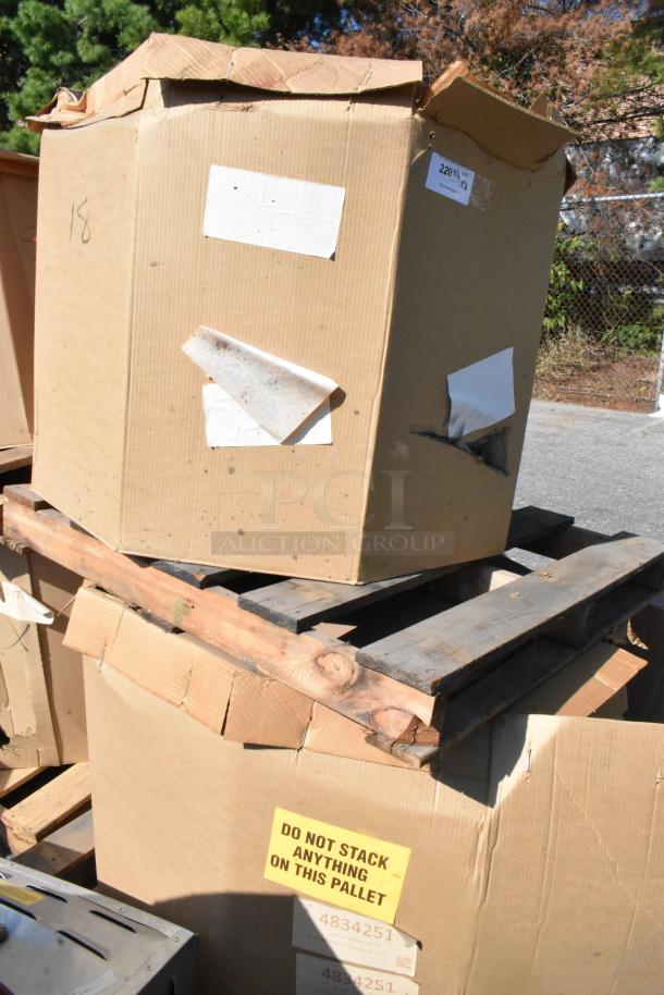 Two new CaptiveAire DMUA18FA metal rooftop exhaust fans in boxes on pallets. "Do Not Stack" label visible.