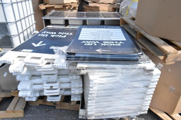 Stack of 20 A-frame sidewalk signs, new condition, white frames with "Pick Up This Way" signage, wrapped on pallets.