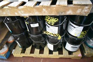 Twelve black Pro Guard chemical containers, including 5-gallon 2114 Moisture Cure Primer Clear Blue, stacked on a pallet.
